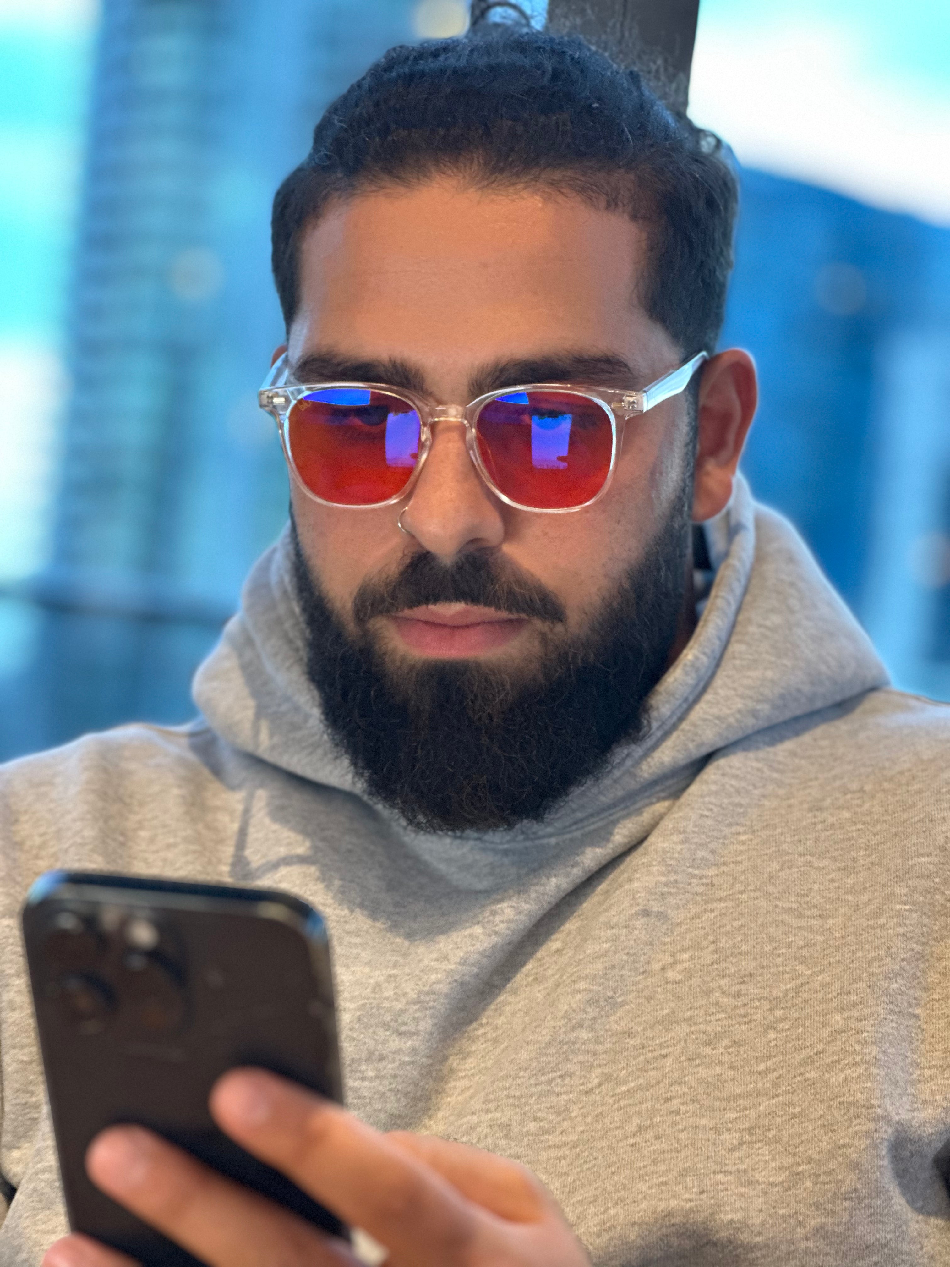 man wearing blue light glasses on phone