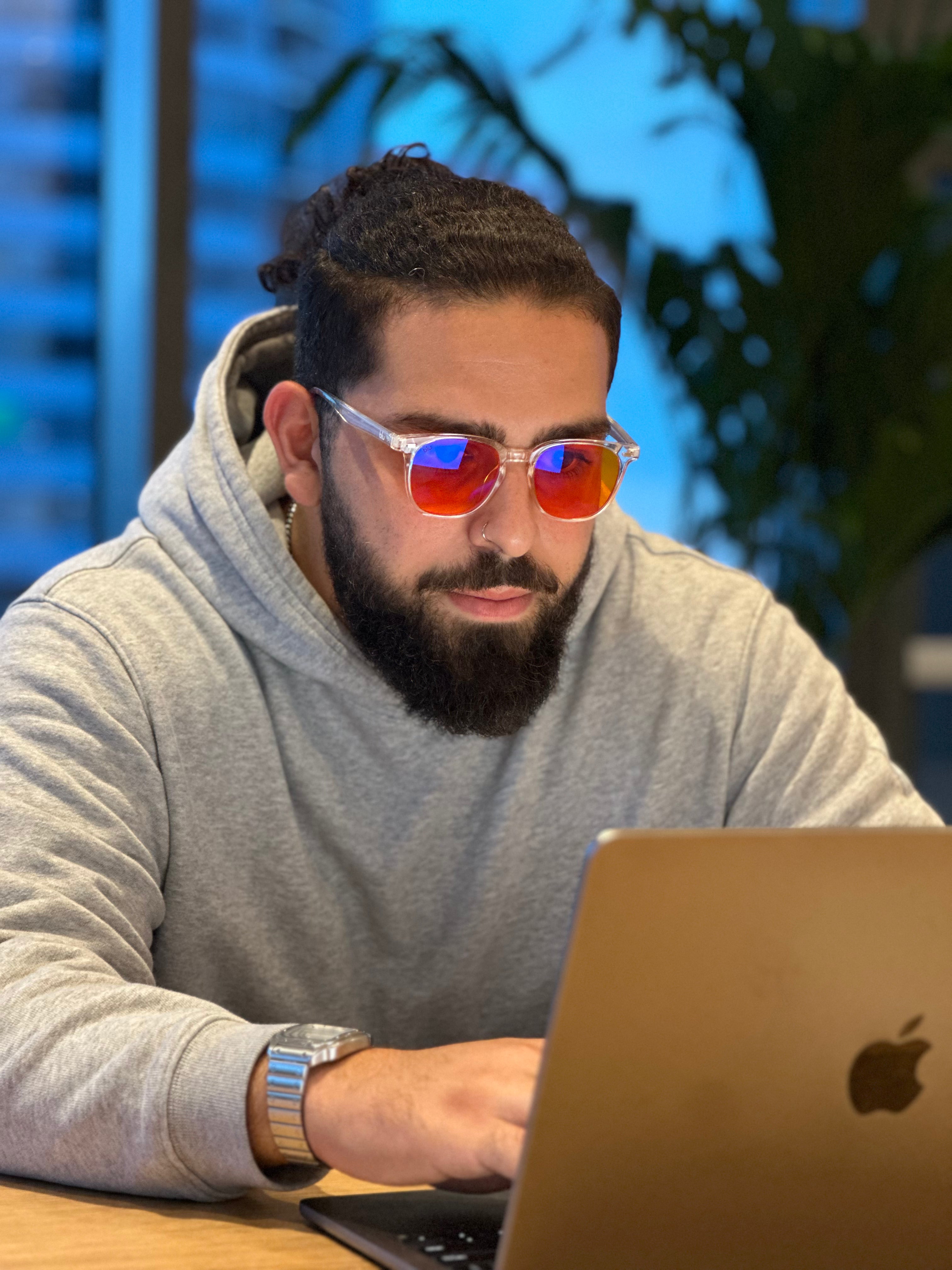 man wearing blue light glasses on computer
