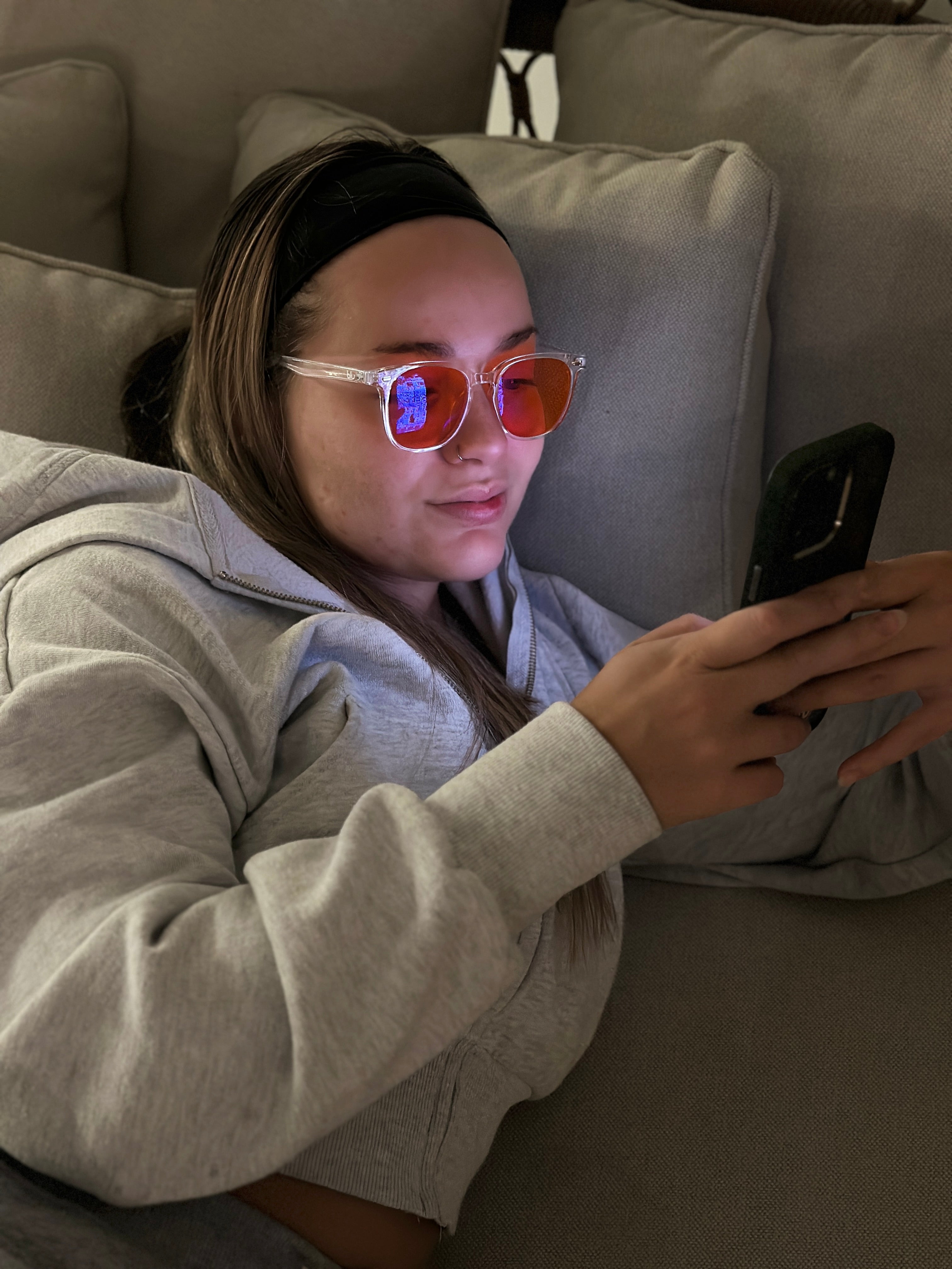 woman wearing blue light glasses in bed